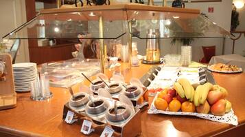 A buffet counter with various food items and condiments.