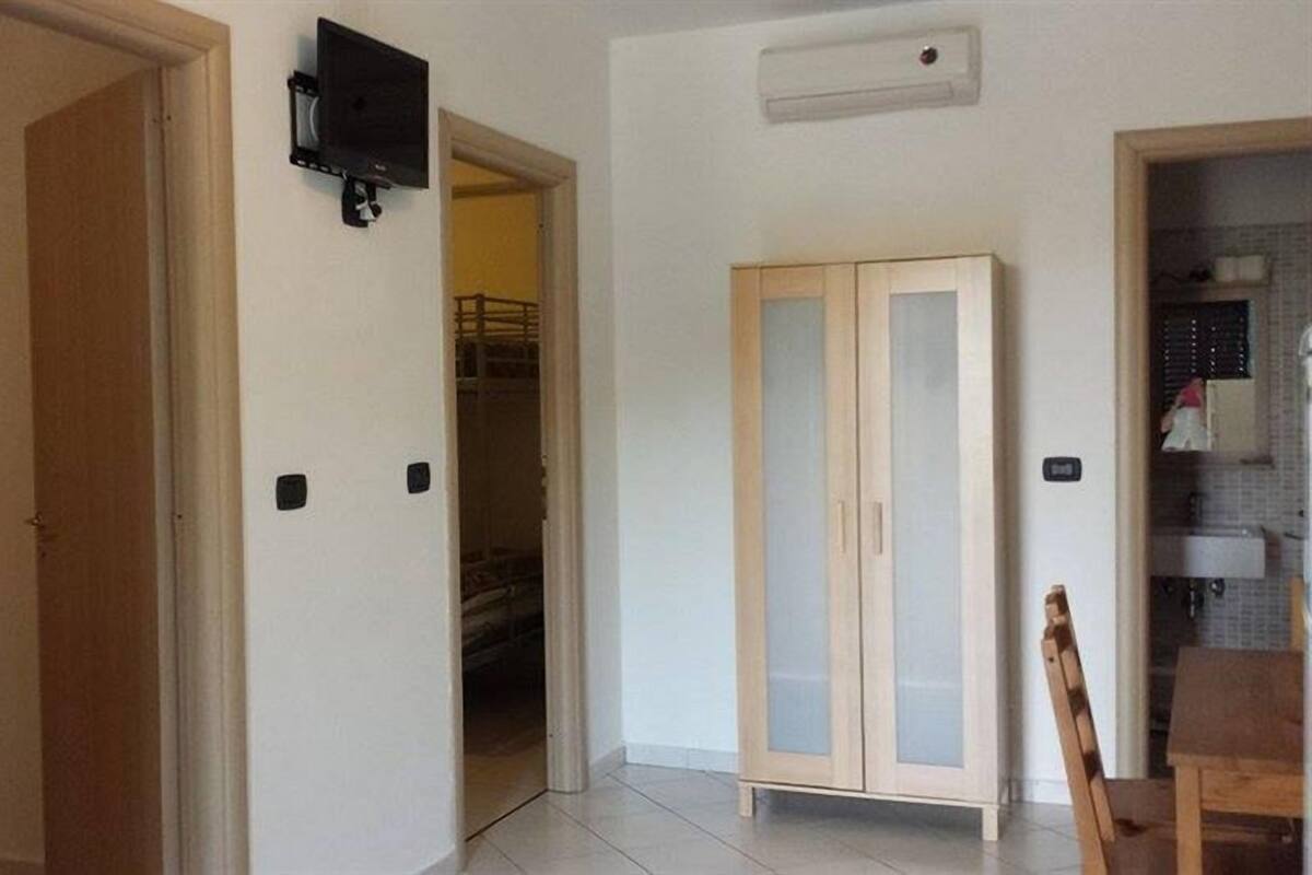 Ein Flur mit einer Holztür, einem Schrank mit Glastüren und einem schwarzen Gerät an der Wand.
