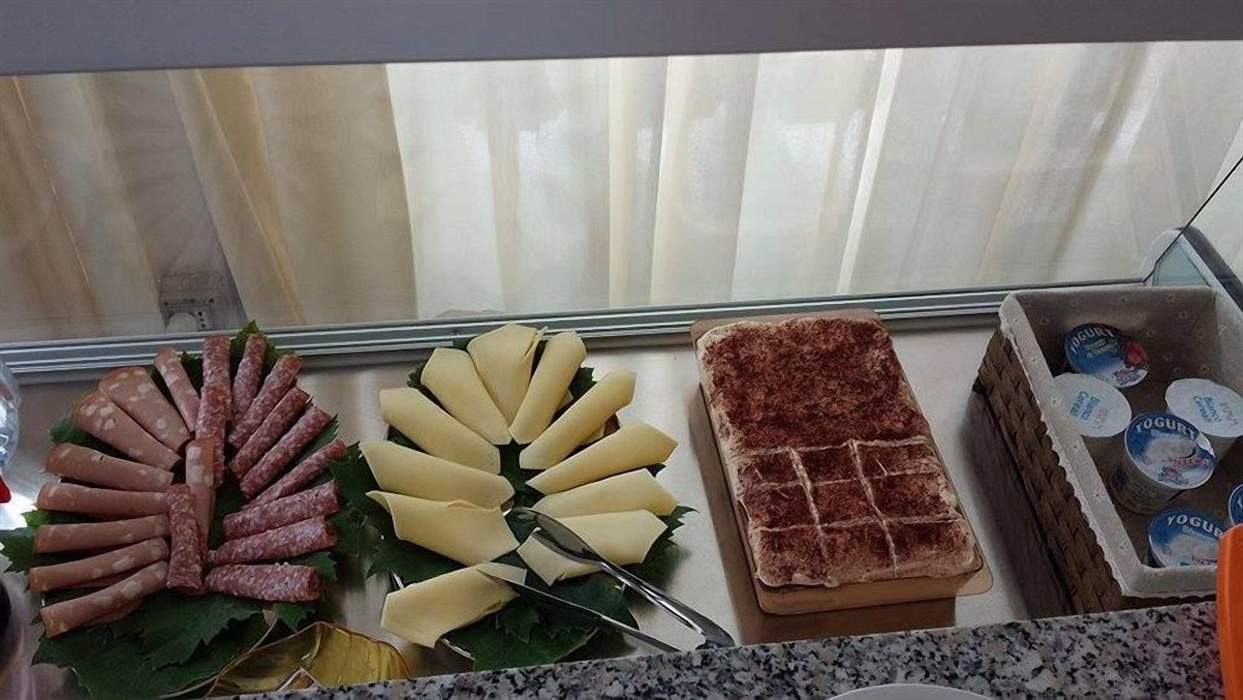 Un buffet proposant une variété d'aliments, notamment des saucisses, du fromage et du pain.