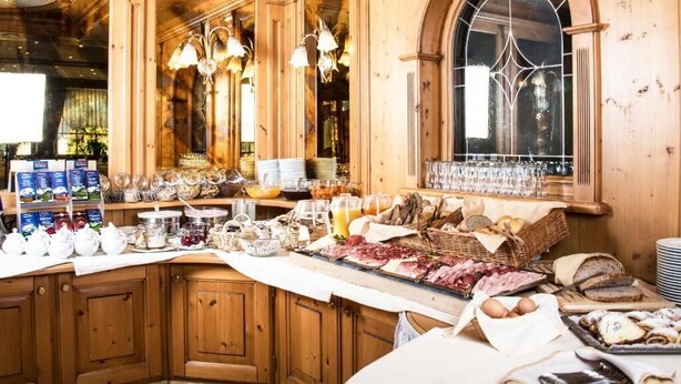 A breakfast buffet with various food items, glassware, and tea sets. - Turmhotel Gschwendt (Valle di Casies)