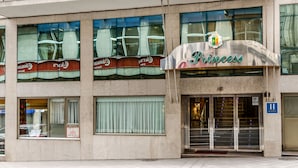 A hotel named "Princess" with a modern facade, large windows, and a visible entrance with an elevator.