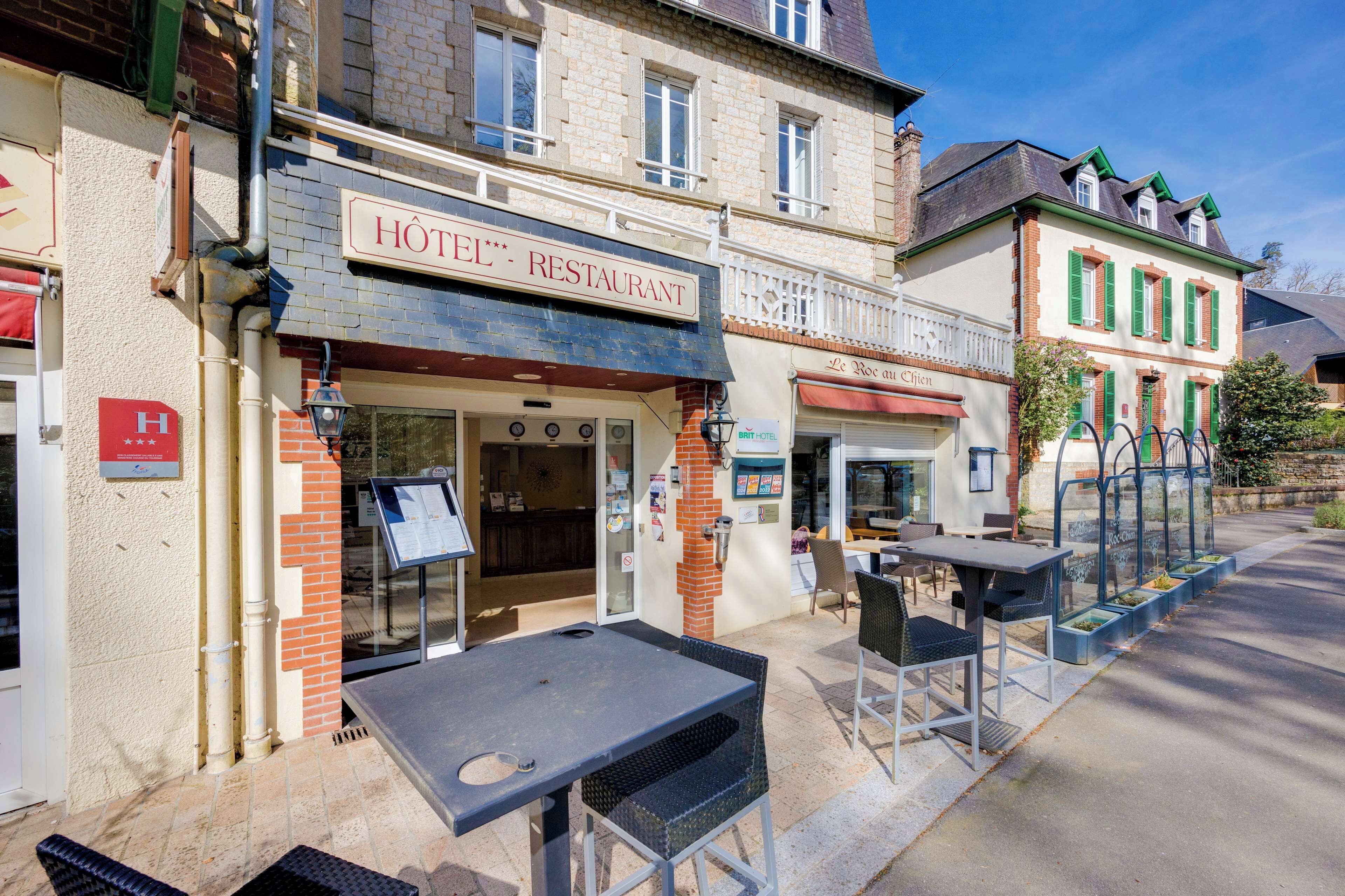 Un restaurant d’hôtel avec une terrasse, une enseigne et une entrée bien visible.