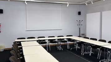 A conference room with a long table, chairs, a projector, and a whiteboard.