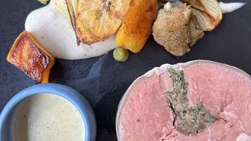 A plate with various food items including a piece of meat, a baked item, and a bowl of soup.