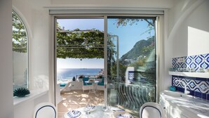 A dining area with a table set for two, overlooking a scenic coastal view. - VILLA FIORENTINO POSITANO  (Positano)