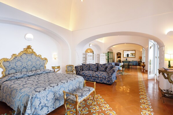 Una habitación amplia con una cama grande, un sofá y un comedor con una mesa y sillas.