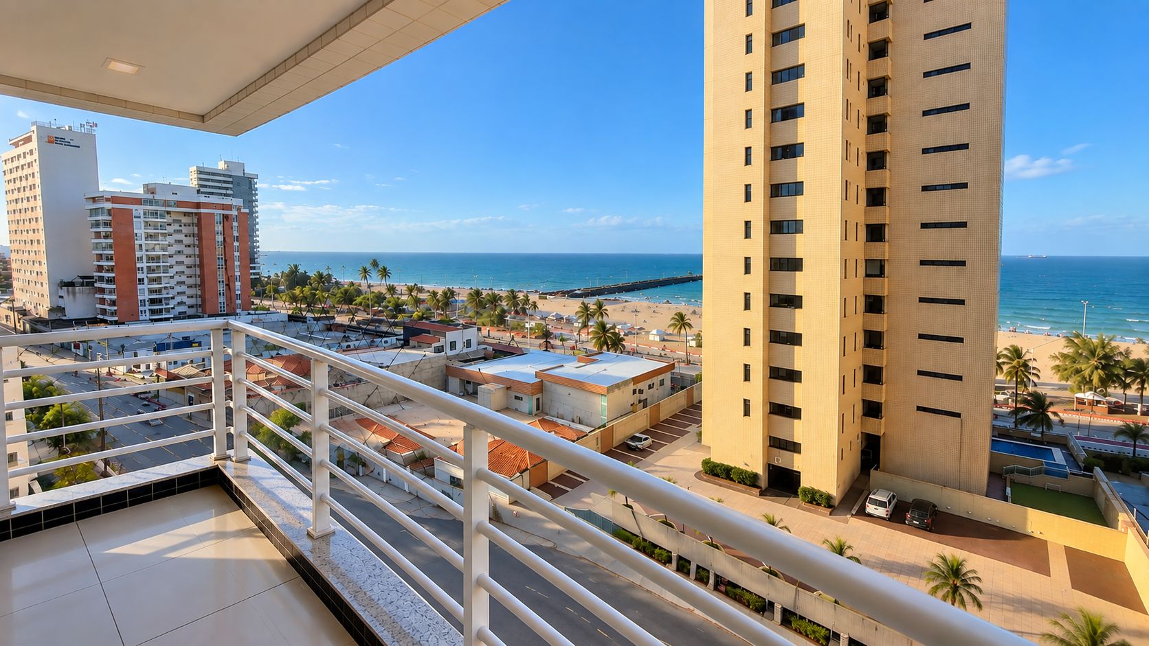 Un balcón con vista a una playa y edificios altos.