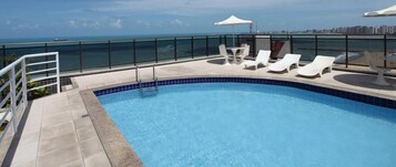 Una piscina techada, sillones reclinables de piscina