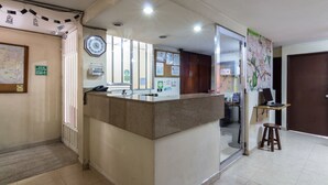 A reception area with a counter, a map on the wall, and a bulletin board with notices.