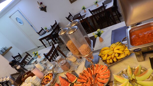 Un bufé con diversos alimentos, entre ellos frutas, ensaladas y salsas.