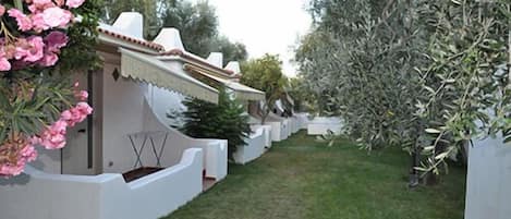 A pathway leading to a building with a white exterior and a tiled roof.