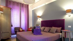 Un dormitorio con una cama grande, un armario, una silla y una mesita.