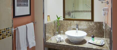 A bathroom with a sink, mirror, towel rack, and a framed picture on the wall.