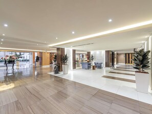 A spacious lobby with a reception desk, seating area, and a large potted plant. - Novotel Suites Riyadh Olaya (Riyadh)