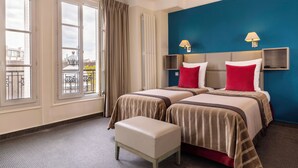 A hotel room with two beds, a view of the city, and a balcony. - Hotel Saint Pierre (Paris)
