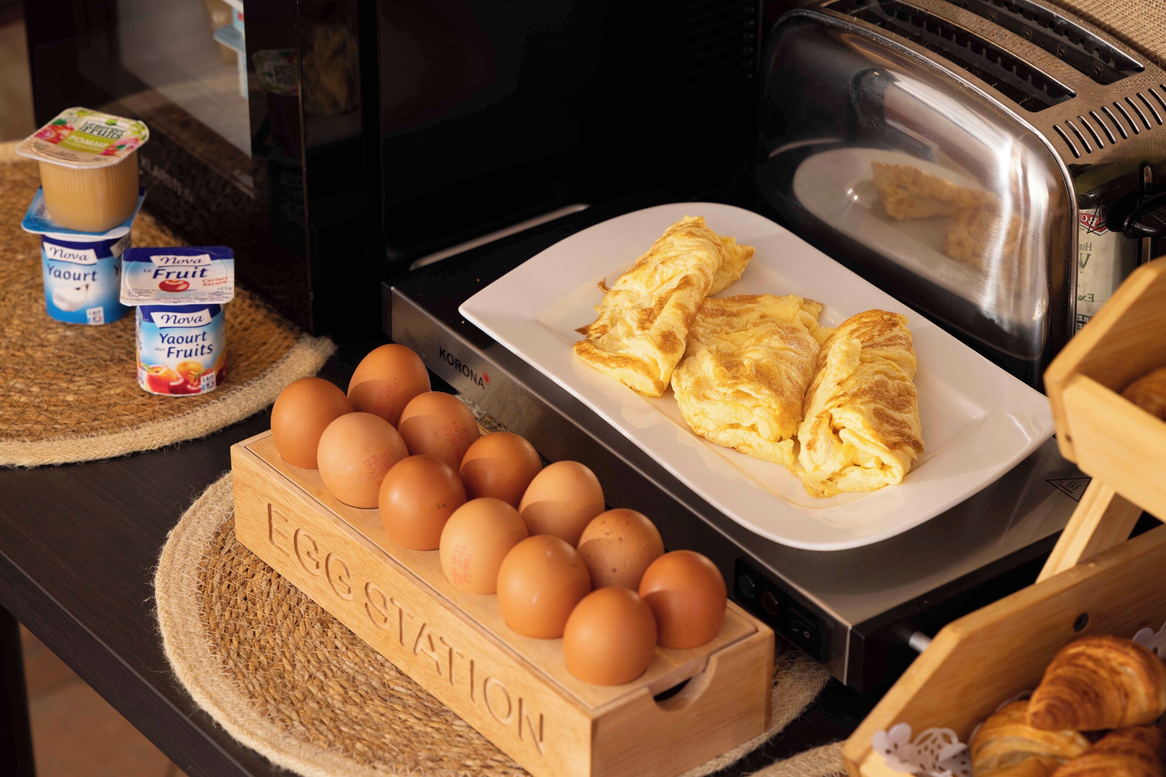 Un petit-déjeuner composé d’œufs, de yaourt aux fruits et de croissants.