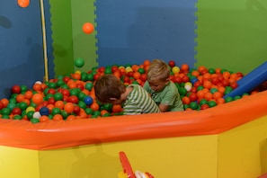 Two children playing in a colorful ball pit with a slide. - Wirtshaushotel Alpenrose (San Lorenzo di Sebato)