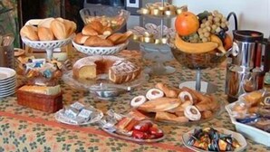 Un buffet proposant une variété d’aliments, notamment du pain, des fruits et des pâtisseries.