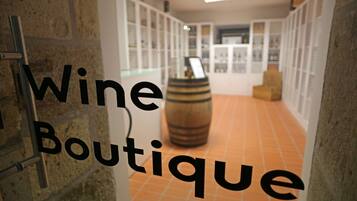 Una boutique de vinos con pared de piedra y suelo de baldosas.