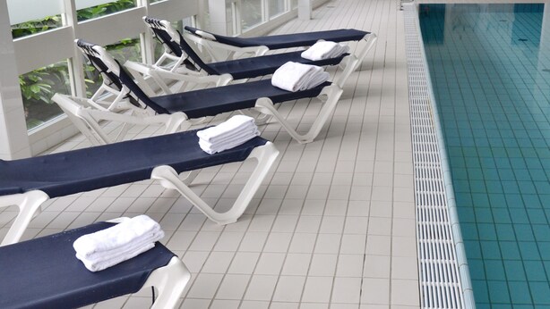 A poolside area with lounge chairs and a pool.