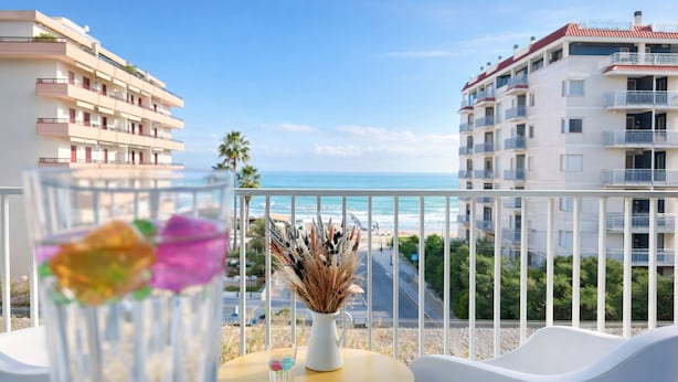 A balcony with a clear view of the sea and buildings. There is a vase with dried flowers and a glass with colorful objects. - Residence I Delfini (Cupra Marittima)