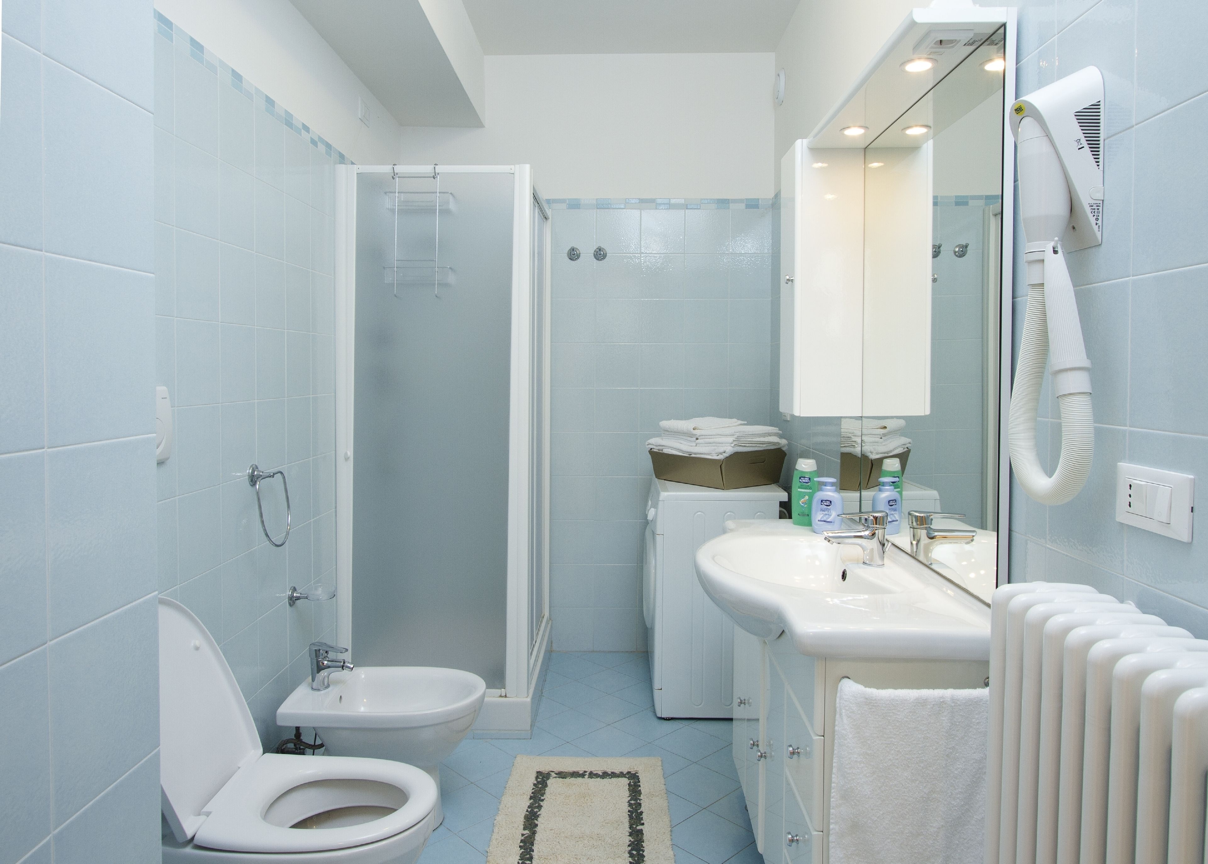 Un baño moderno con inodoro, bidé, ducha y lavabo.