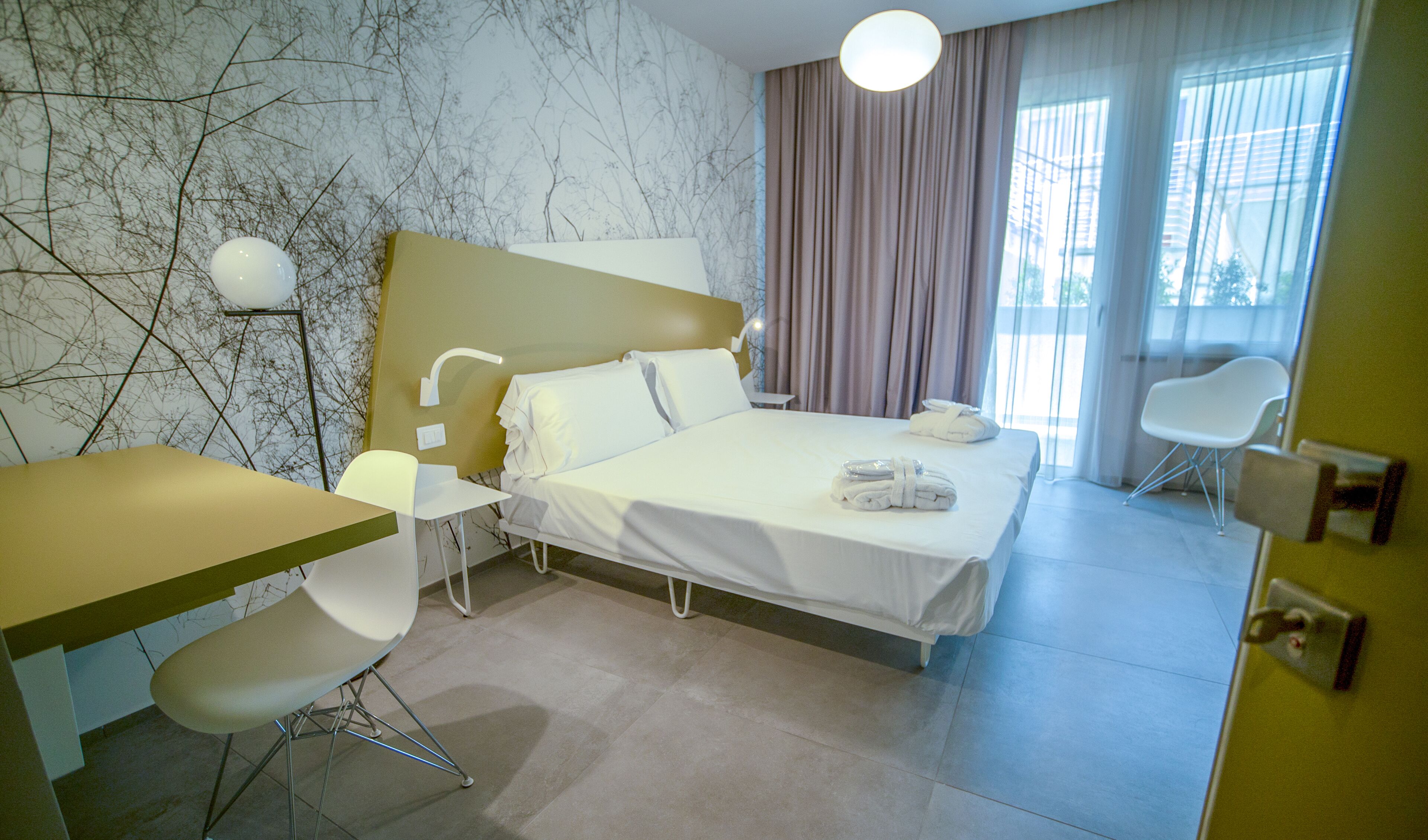 Een hotelkamer met een bed, een bureau en twee stoelen.