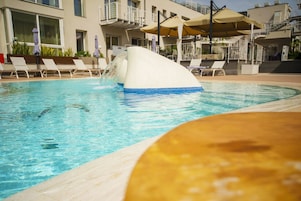 Una piscina al aire libre de temporada, sombrillas