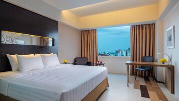 Habitación de hotel moderna con una cama grande, un escritorio y vistas a la ciudad.
