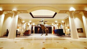 A spacious lobby with a central statue, high ceilings, and classical architecture. - Tianjin Goldin Metropolitan Polo Club (Tianjin)