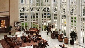 A spacious lobby with a high ceiling and large windows, featuring a central marble fountain and comfortable seating areas. - Tianjin Goldin Metropolitan Polo Club (Tianjin)