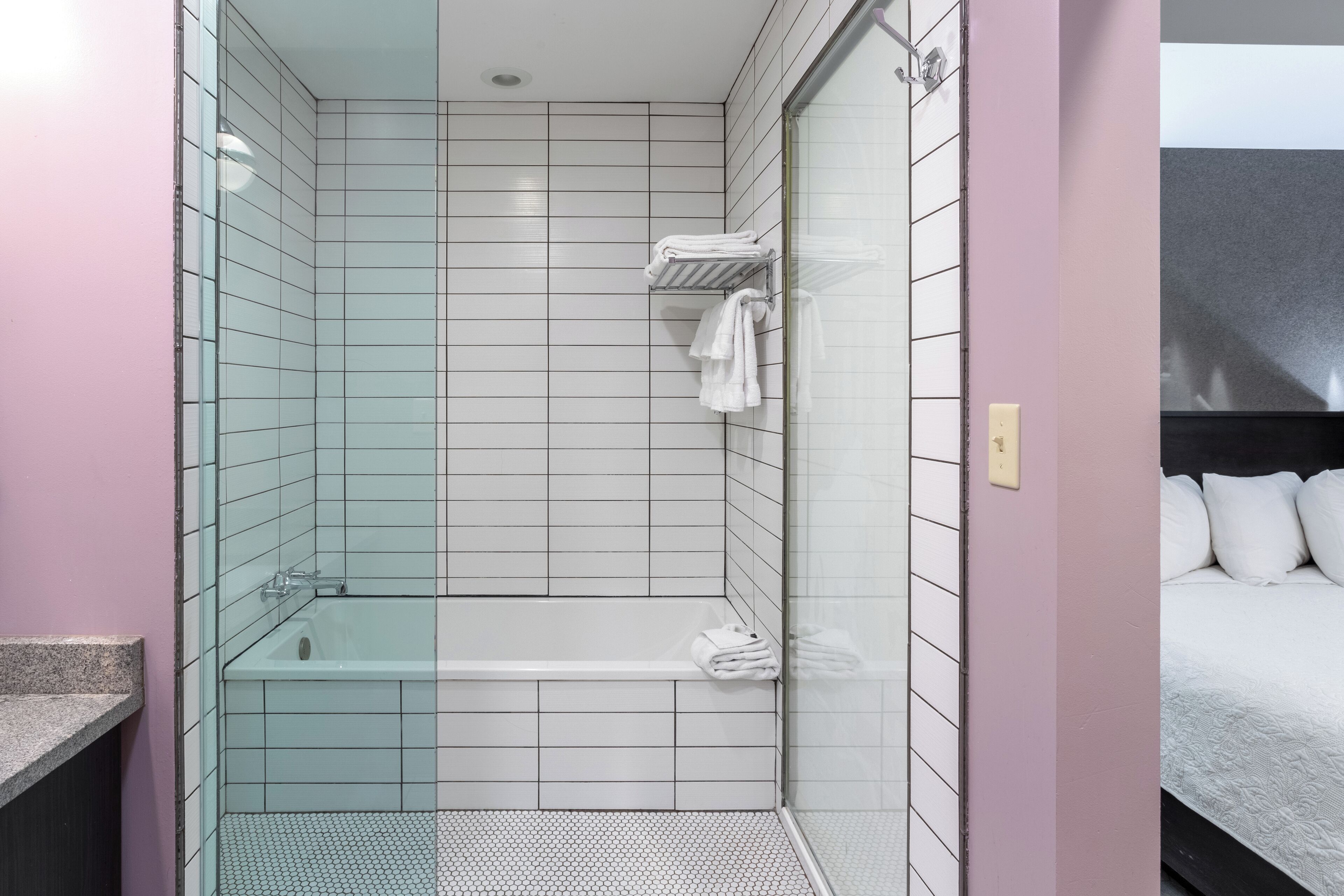 Un baño moderno con cabina de ducha de vidrio, bañera y piso de baldosas.