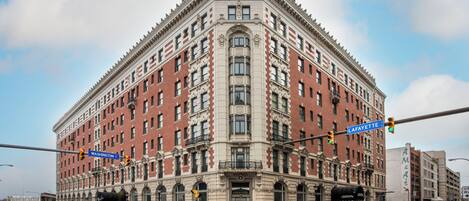 Un edificio grande e histórico con ubicación en la esquina de las calles Lafayette y Washington. Cuenta con una entrada destacada con toldo negro y varias ventanas.