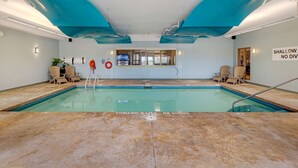 Piscina con un cartello che indica acqua bassa e divieto di tuffi.