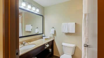 A bathroom with a sink, mirror, towel rack, and toilet.