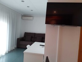 Habitación cuáddruple con terraza, 4 personas | Zona de estar | Una televisión