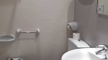 Een badkamer met een toilet, wastafel en een bidet.