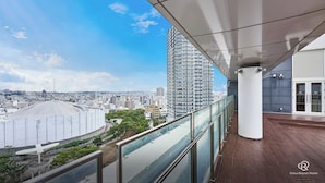 A Daiwa Roynet Hotel balcony with a view of a cityscape and a tall building.