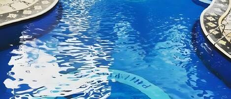 Alberca al aire libre y camastros