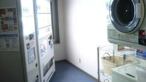 A laundry room with a washing machine and dryer, a window, and a blue floor. - Hotel Excel Okayama (Okayama)