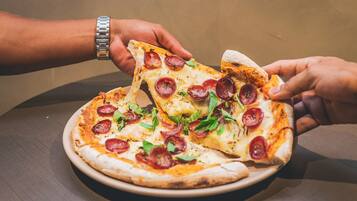 Pizza com pepperoni e vegetais em um prato.