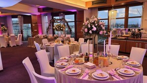 A banquet hall with round tables set for a formal event, featuring floral centerpieces and candle holders. - Hotel Vestil (Piotrkow Trybunalski)