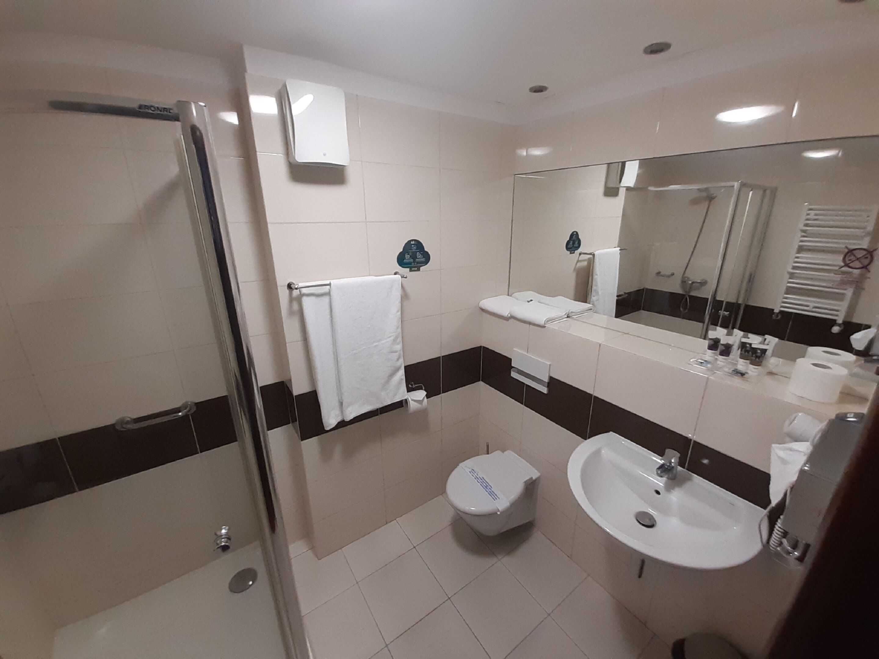 Ein modernes Badezimmer mit Duschkabine aus Glas, einem weißen Waschbecken und einer Toilette.