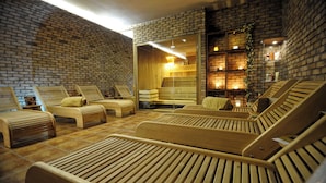 A spa area with wooden loungers, a brick wall, and a wooden sauna. - Hotel Vestil (Piotrkow Trybunalski)