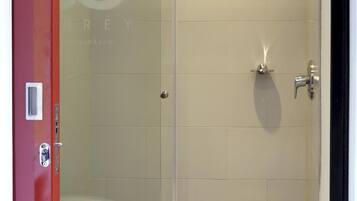 Divisória de chuveiro com vidro e vaso sanitário visível através do vidro.