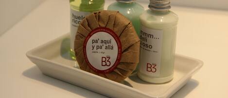 A tray with three bottles of liquid soap and a brown paper bag with a label.