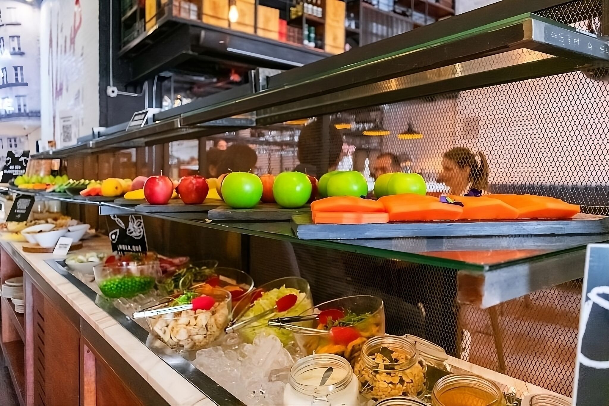 A buffet with various food items and a salad bar.