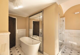 A bathroom with a freestanding bathtub, a glass-enclosed shower, and a large mirror.