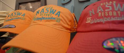 A row of caps with text indicating they are from Nashwa Resort.