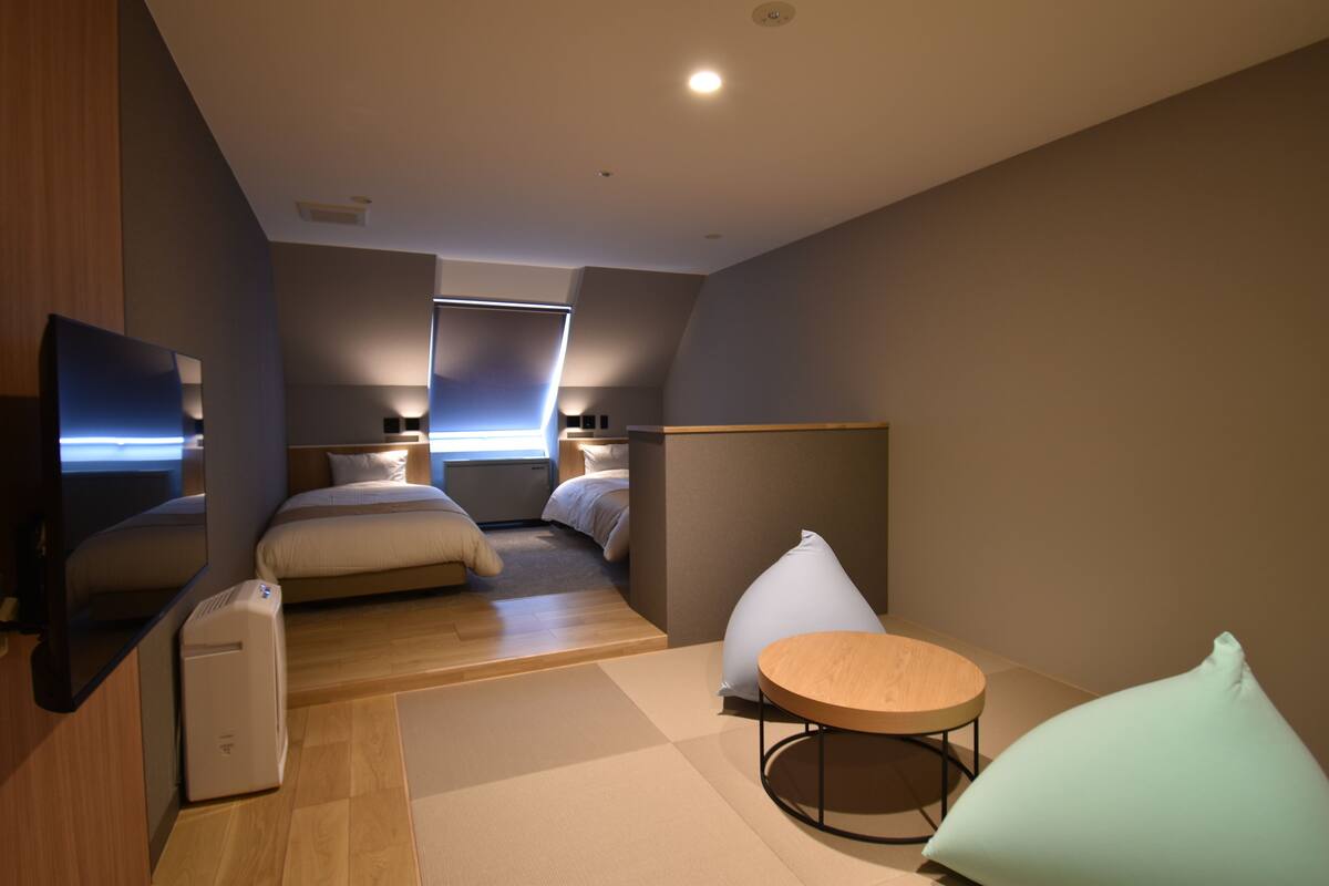 Una habitación de hotel moderna con cama, escritorio, silla y televisor.